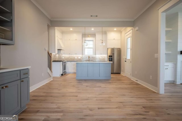 kitchen featuring ornamental molding, stainless steel appliances, and light hardwood / wood-style flooring