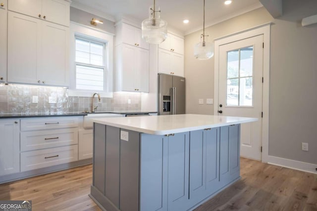 kitchen featuring white cabinetry, high end refrigerator, and decorative light fixtures