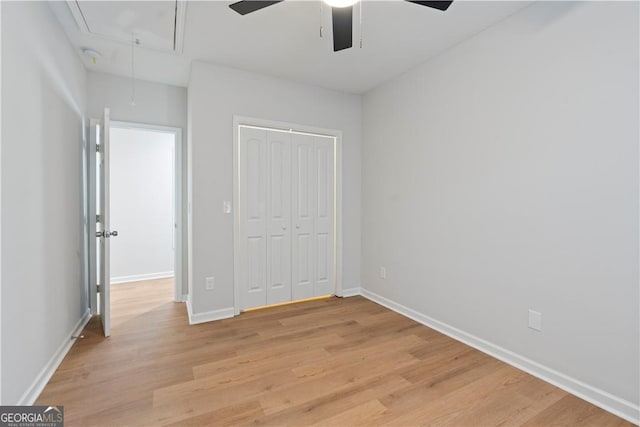 unfurnished bedroom with a closet, light hardwood / wood-style floors, and ceiling fan