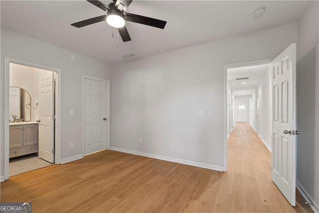 unfurnished bedroom featuring connected bathroom, light hardwood / wood-style floors, and ceiling fan