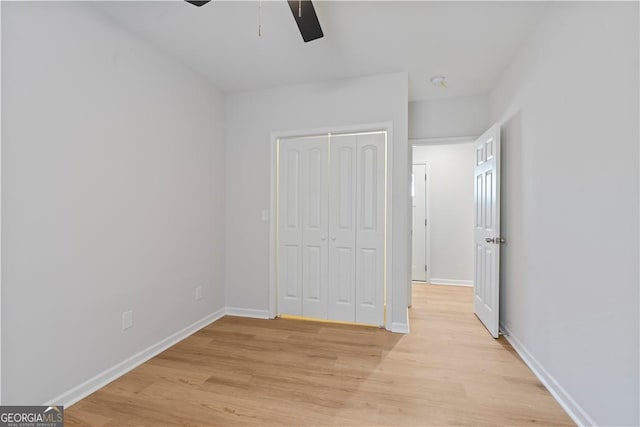 unfurnished bedroom with ceiling fan, a closet, and light hardwood / wood-style floors