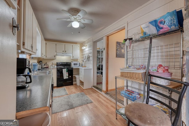 kitchen featuring white cabinets, sink, ceiling fan, black / electric stove, and light hardwood / wood-style floors