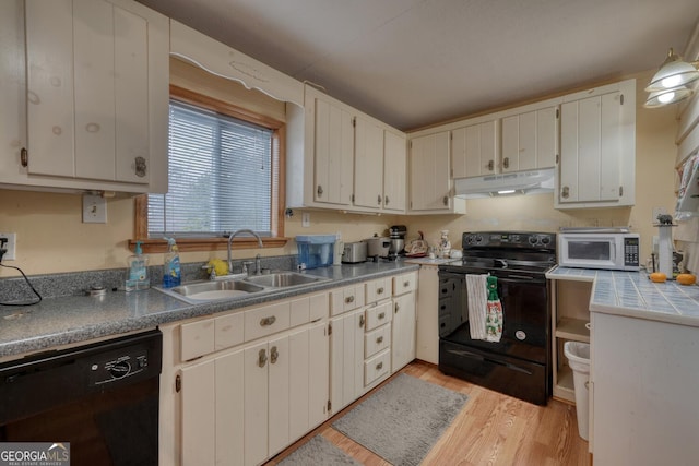 kitchen with black appliances, white cabinets, sink, and light hardwood / wood-style flooring