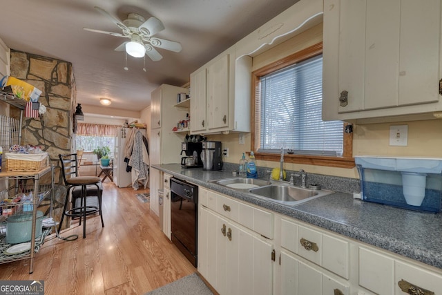 kitchen with sink, white cabinetry, black dishwasher, and light hardwood / wood-style flooring