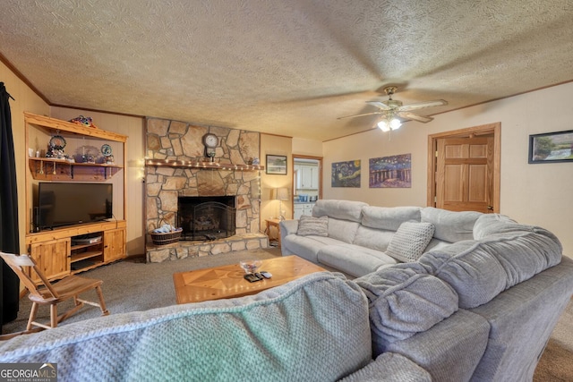 living room featuring a stone fireplace, carpet flooring, ceiling fan, ornamental molding, and a textured ceiling