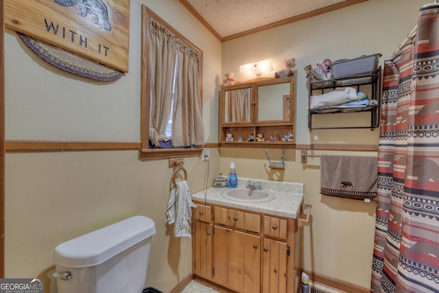 bathroom with toilet, vanity, a textured ceiling, and ornamental molding