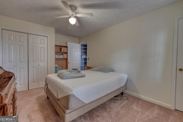 carpeted bedroom with a textured ceiling, a closet, and ceiling fan