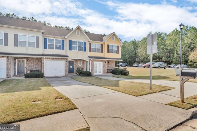 multi unit property featuring a garage, a front yard, and french doors