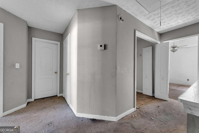 corridor featuring a textured ceiling and light carpet