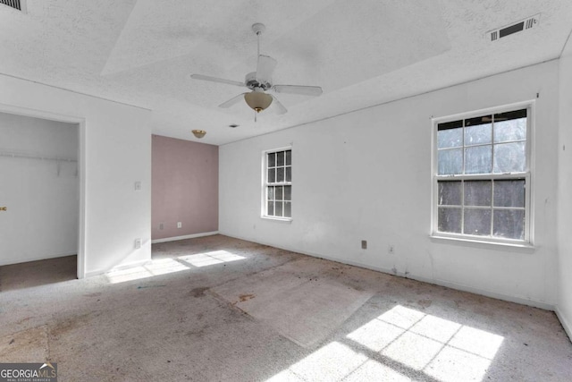 unfurnished bedroom featuring ceiling fan, a textured ceiling, and a closet