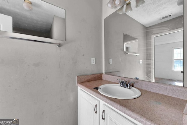 bathroom featuring a textured ceiling and vanity