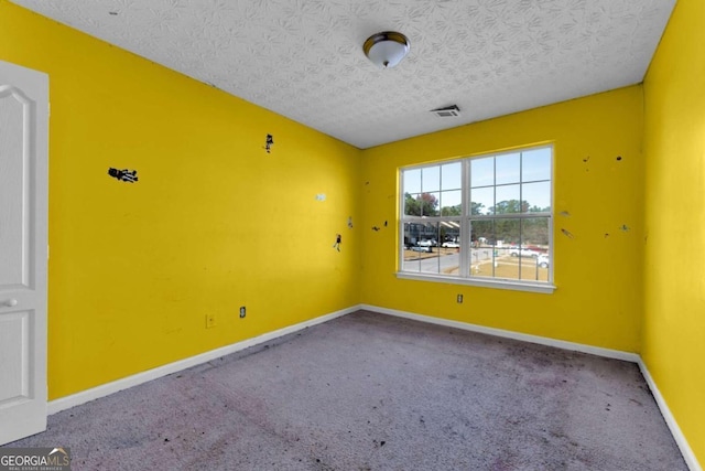 carpeted spare room featuring a textured ceiling