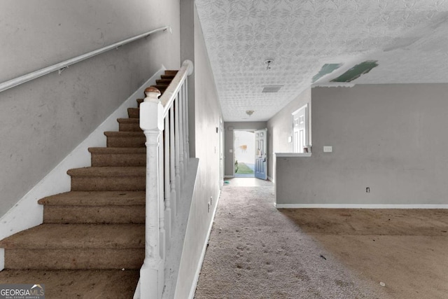 stairway featuring carpet flooring