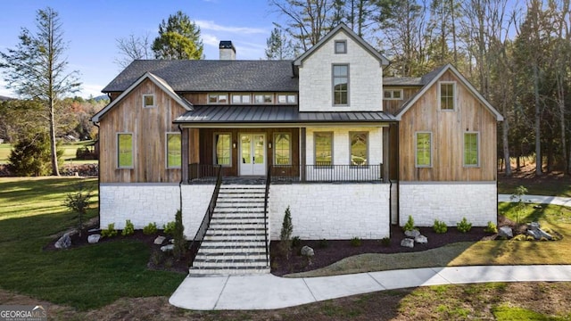 modern farmhouse featuring covered porch and a front lawn