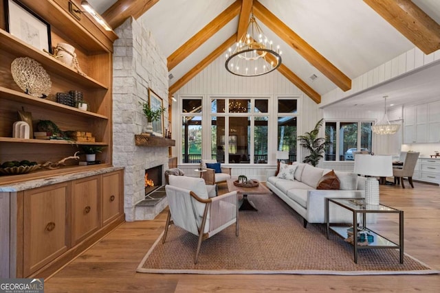 living room with high vaulted ceiling, light wood-type flooring, a fireplace, and an inviting chandelier