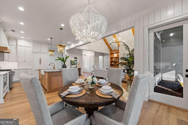 dining room featuring built in shelves, ornamental molding, a notable chandelier, and light wood-type flooring