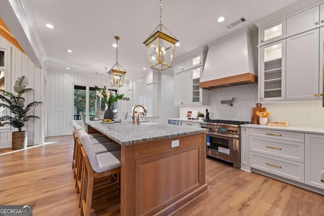 kitchen featuring stainless steel range, premium range hood, and white cabinets