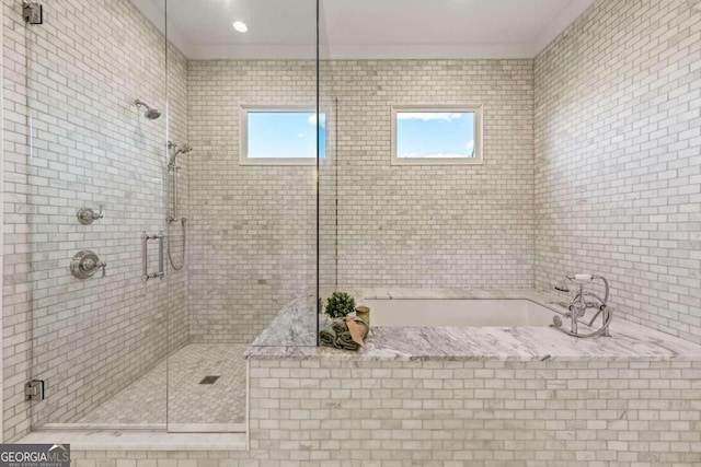 bathroom with ornamental molding and separate shower and tub