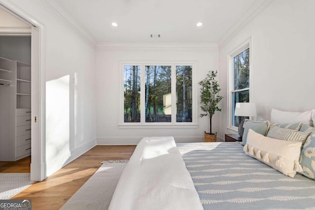 bedroom featuring light wood-type flooring and crown molding