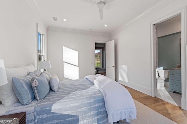 bedroom with ceiling fan, crown molding, connected bathroom, and hardwood / wood-style flooring