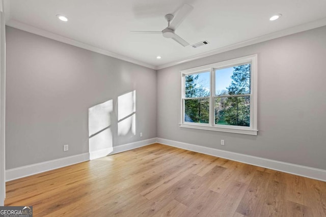 empty room with ceiling fan, crown molding, and light hardwood / wood-style floors