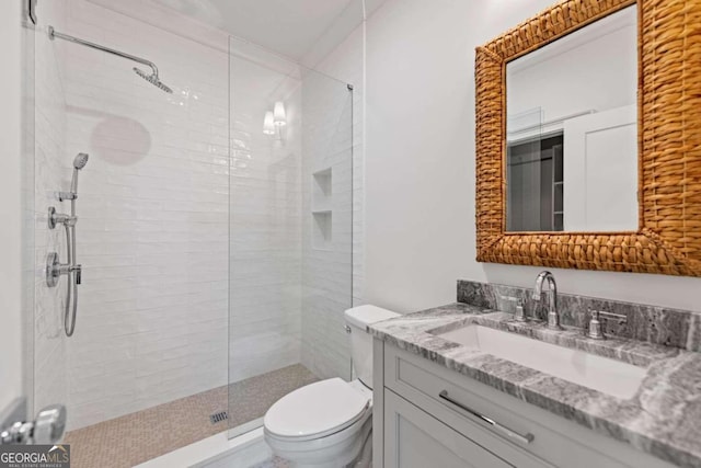 bathroom featuring toilet, vanity, crown molding, and a tile shower