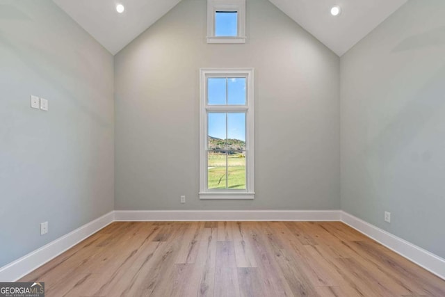 unfurnished room featuring light wood-type flooring and high vaulted ceiling