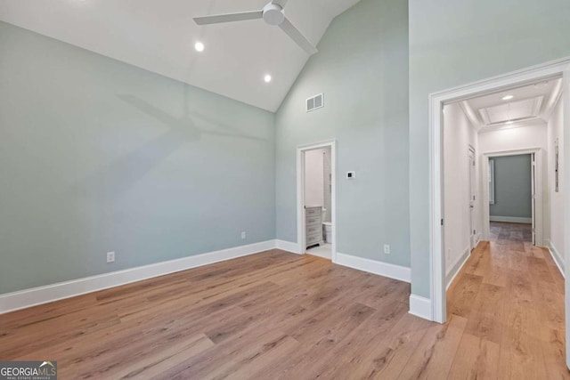 unfurnished bedroom featuring high vaulted ceiling, ensuite bath, ceiling fan, and light hardwood / wood-style flooring