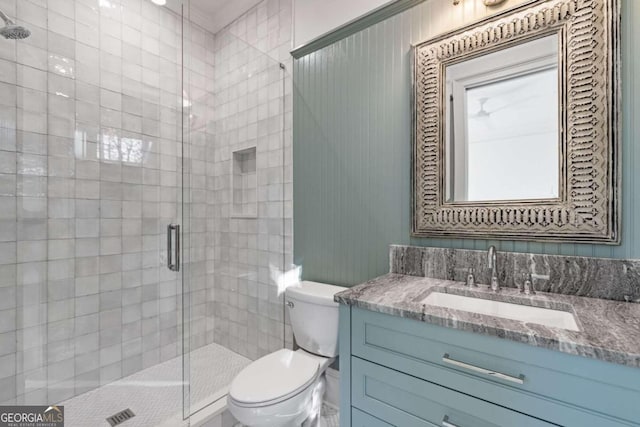 bathroom with a shower with shower door, vanity, and toilet