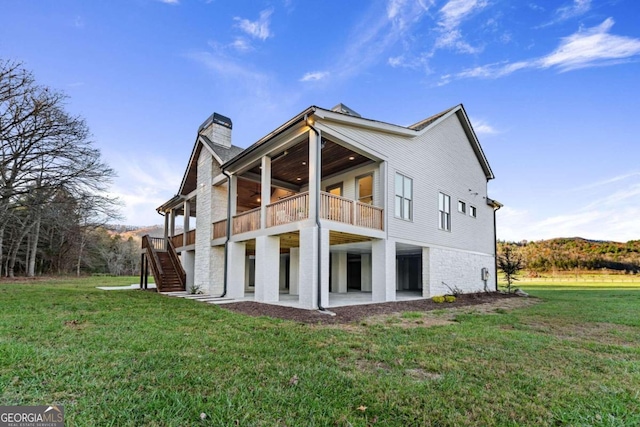 back of property featuring a patio area, a balcony, and a yard