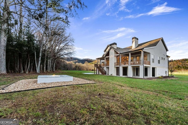 back of house featuring a wooden deck and a lawn