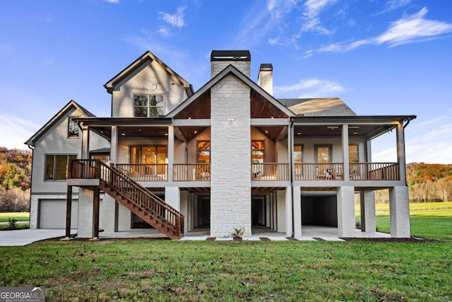 rear view of property featuring a garage, a lawn, and a patio