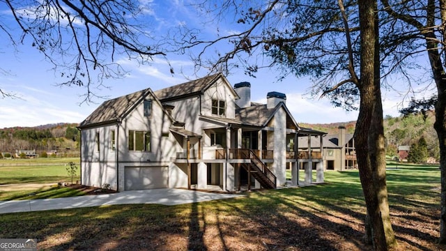 back of house with a lawn and a garage