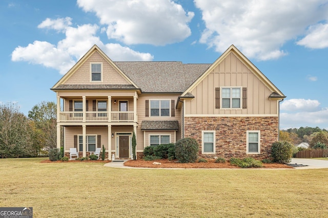 craftsman-style house with a balcony and a front lawn