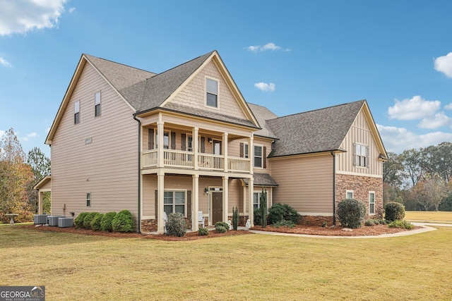 view of front of home featuring a balcony, a front lawn, and central air condition unit