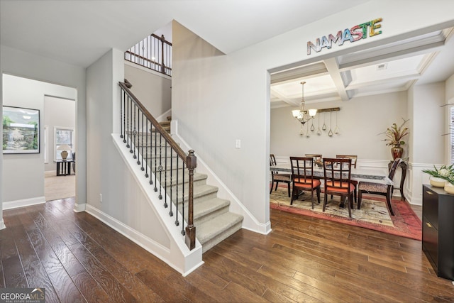 stairway with wood-type flooring, beam ceiling, coffered ceiling, and a notable chandelier