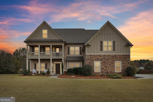 craftsman-style home featuring a balcony and a lawn