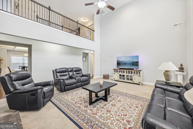 living room featuring ceiling fan, carpet, and a high ceiling