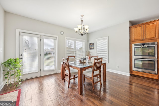 dining space featuring a notable chandelier and dark hardwood / wood-style floors