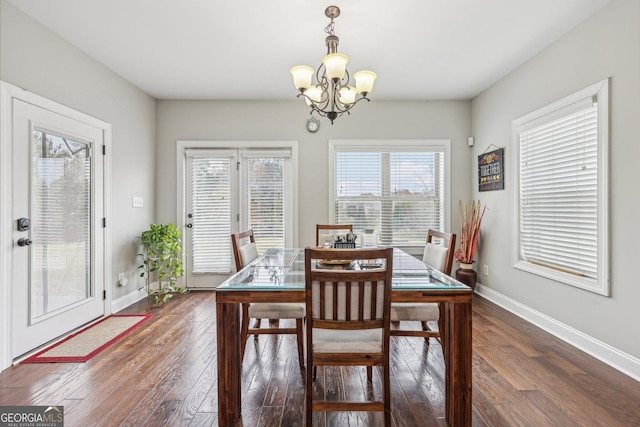 dining room featuring a wealth of natural light, dark hardwood / wood-style floors, and a notable chandelier