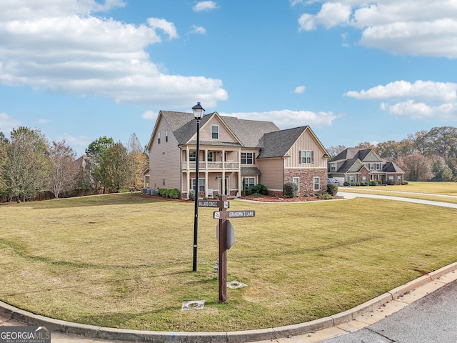 view of front of property featuring a balcony and a front lawn