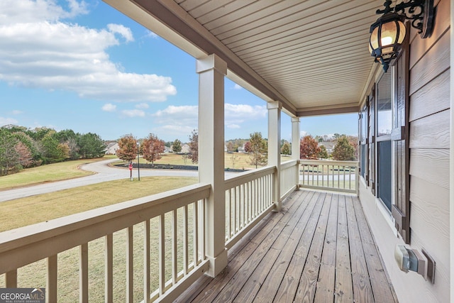 deck featuring covered porch and a yard