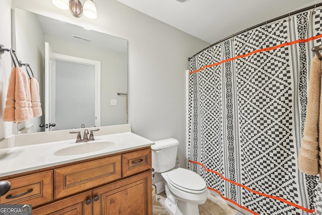 bathroom with tile patterned floors, vanity, toilet, and walk in shower