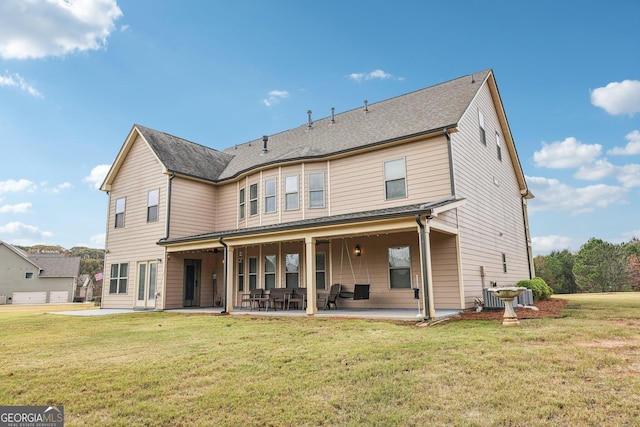 back of house featuring central AC, a patio area, and a lawn