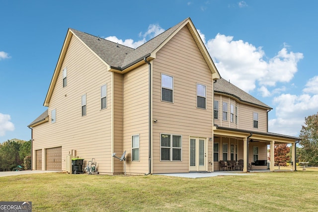 back of property with ceiling fan, a yard, a patio, and a garage