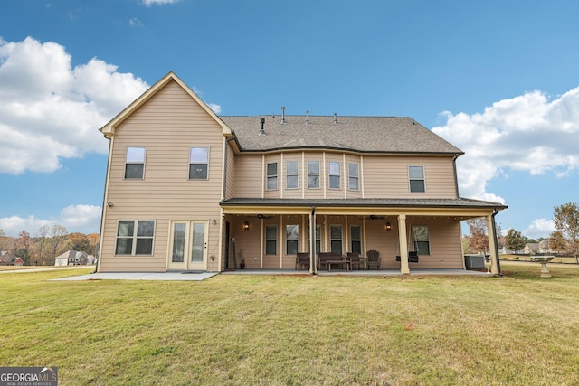 back of property with central AC unit, a patio area, and a lawn