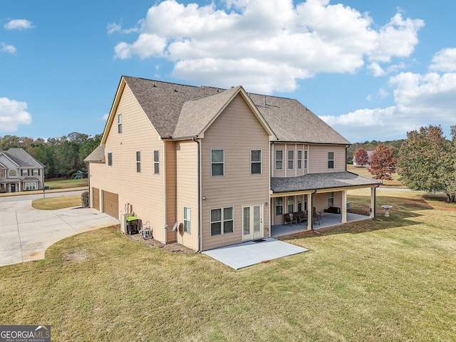 back of property with a lawn, a patio area, central AC unit, and a garage