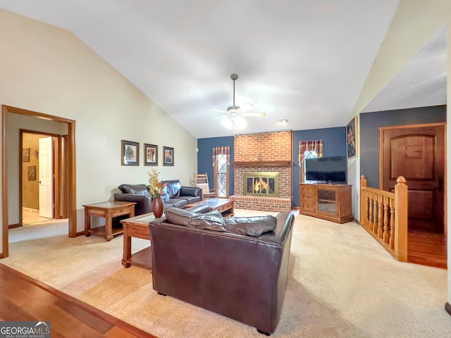 carpeted living room featuring ceiling fan, a fireplace, and vaulted ceiling