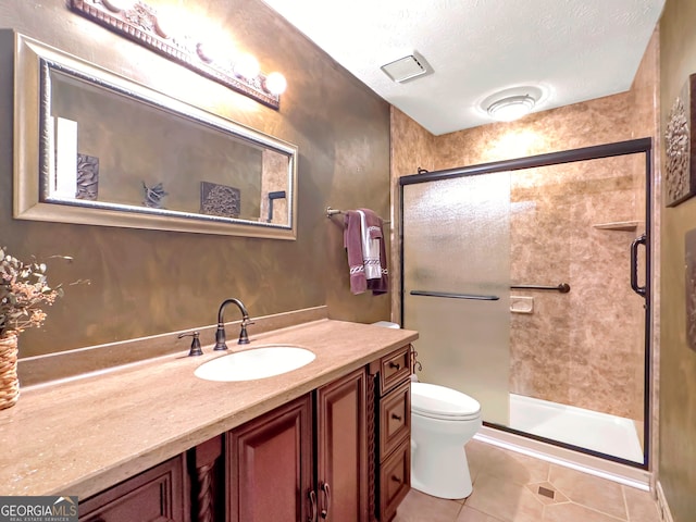 bathroom featuring tile patterned flooring, vanity, a shower with shower door, and a textured ceiling