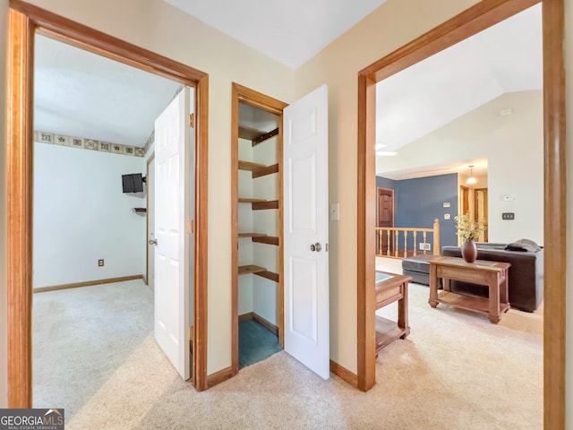 hallway with carpet and lofted ceiling